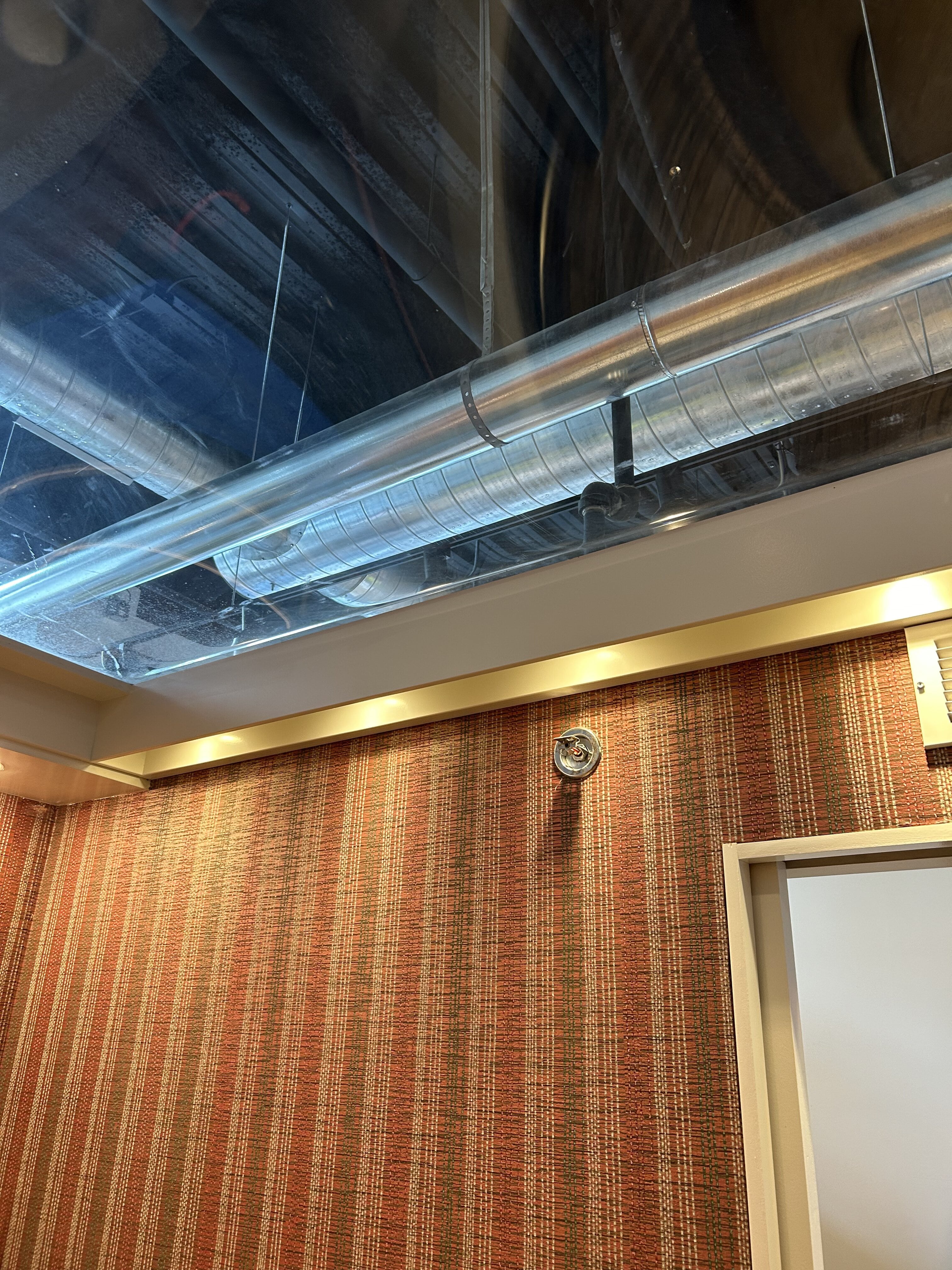 Room with exposed ceiling pipe