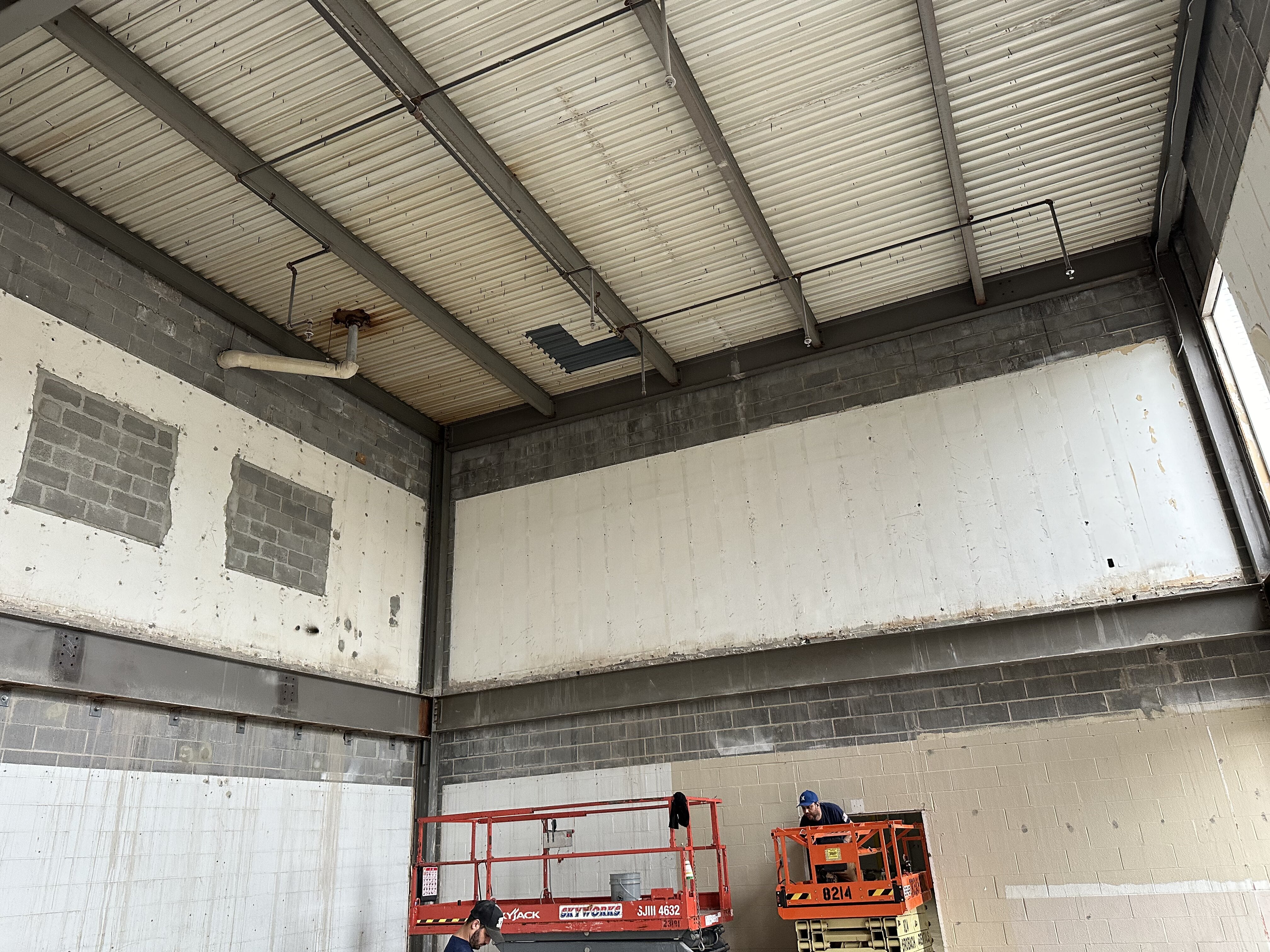 Worker with piping in ceiling