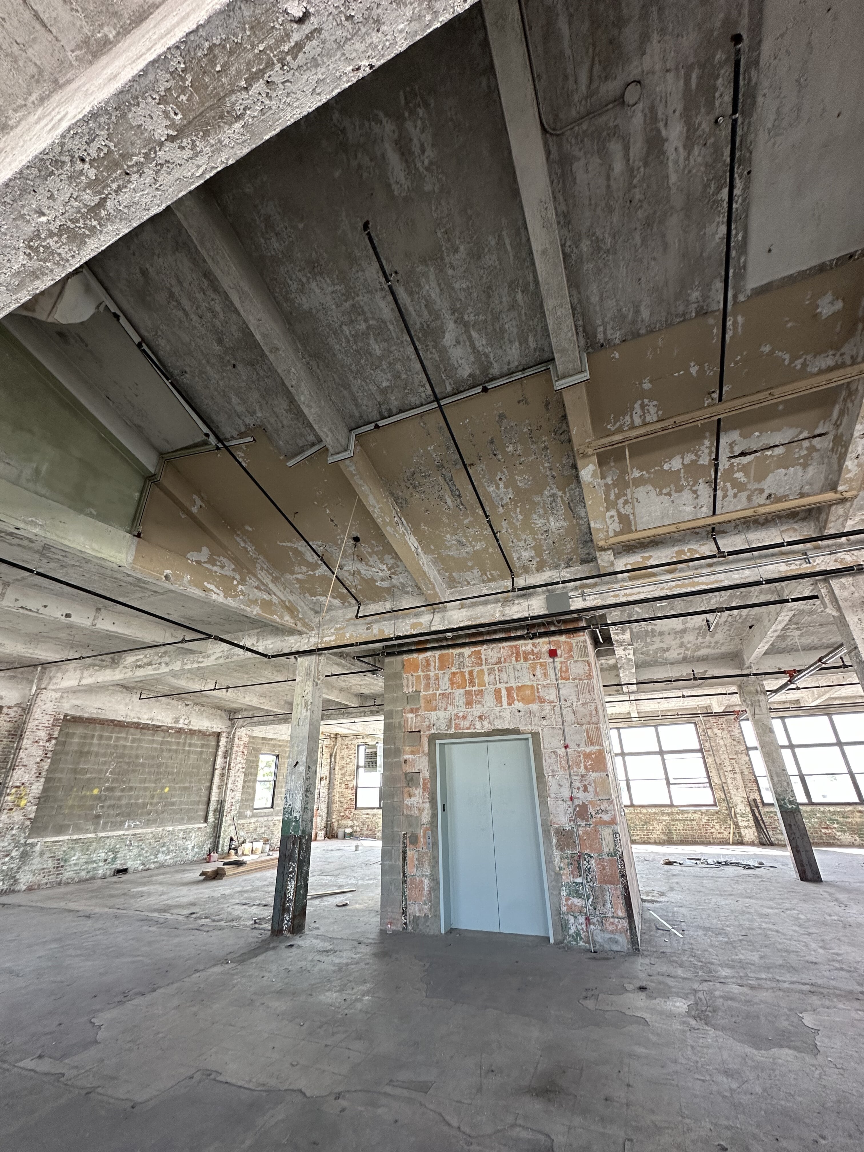 Room with door and exposed ceiling work