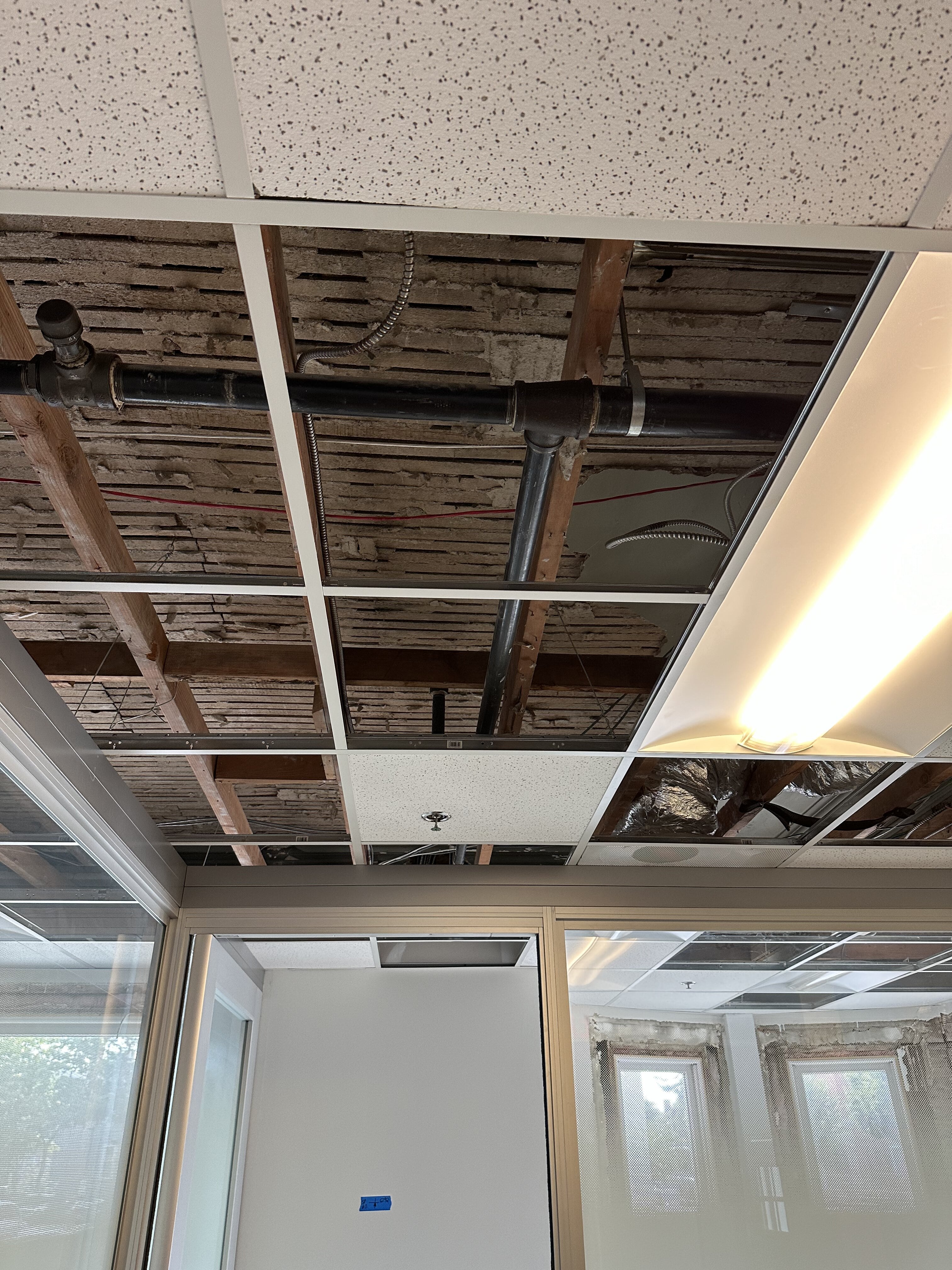 Kitchen area with white refrigerator and exposed ceiling